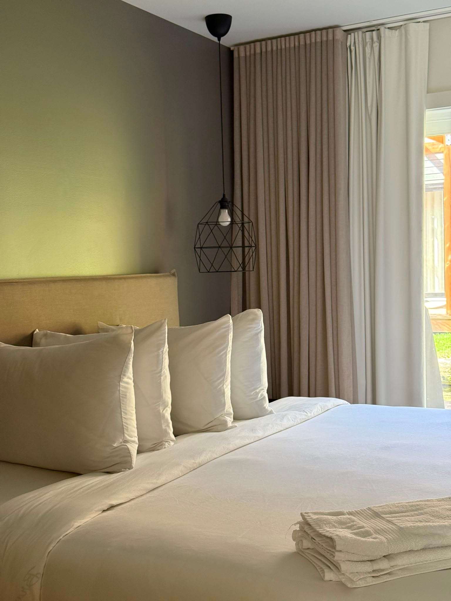 Bed made to the property standard, with fresh towels laid out for the next guests